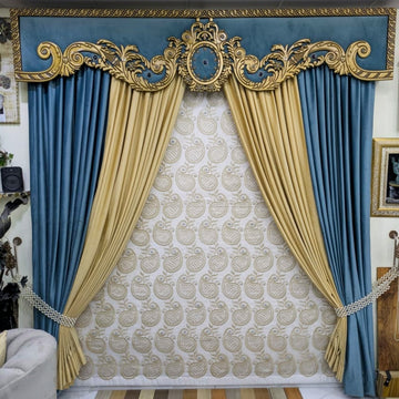 An ornate luxury curtain set with a decorative gold and blue valance, paired with blue side drapes and gold inner drapes over a patterned cream and gold wallpapered wall.